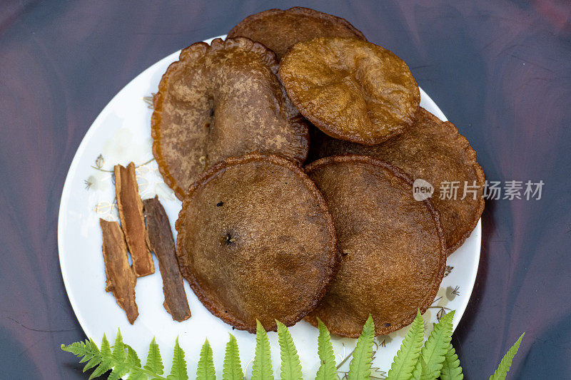 这种食物是由米粉、糖和油制成的。这种物品在孟加拉国被称为tele vaga pitha。它是如此美味。